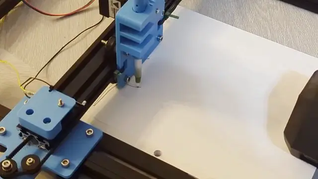 Looks like a 3d printer but it has a pen and is drawing on paper